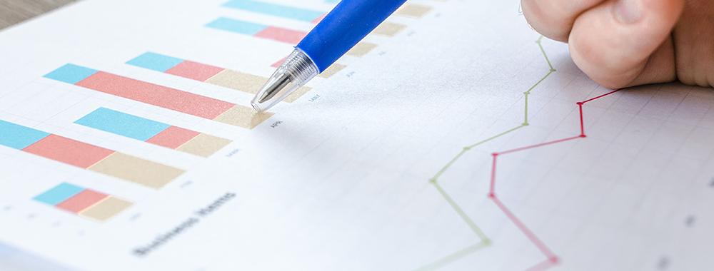man pointing with pen at a spreadsheet