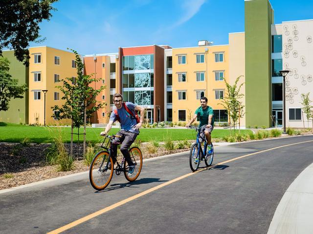 Undergraduate students biking near dorms